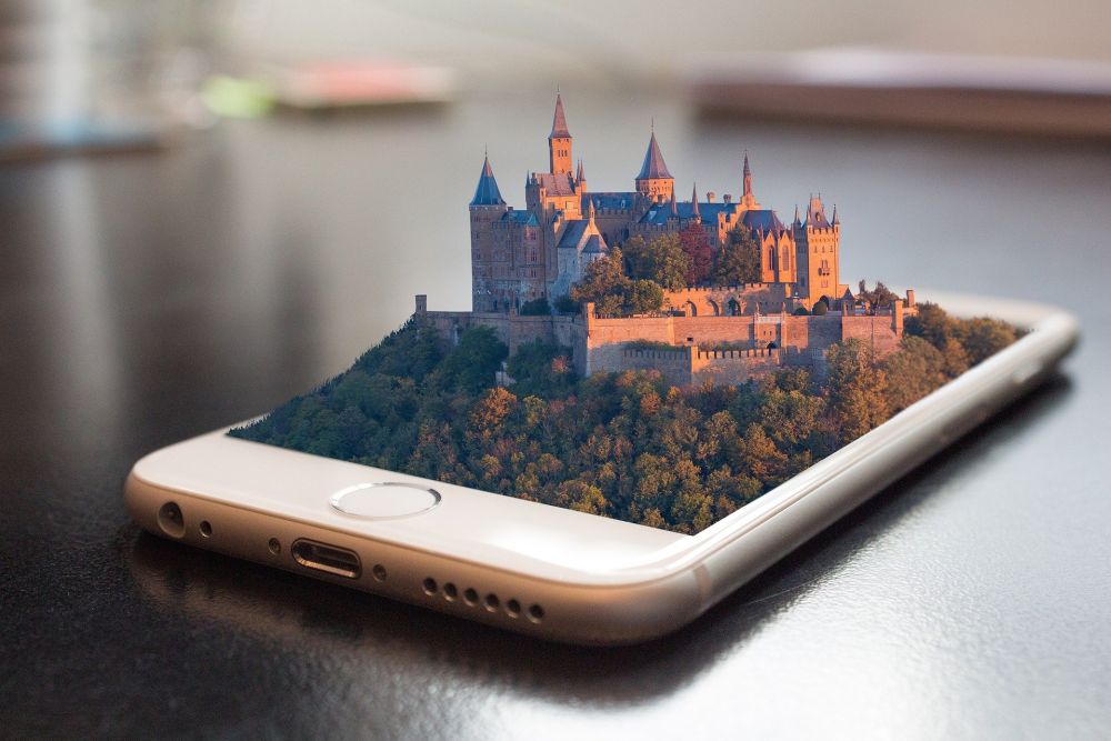 Stylised image of a castle and forest emerging from a smartphone